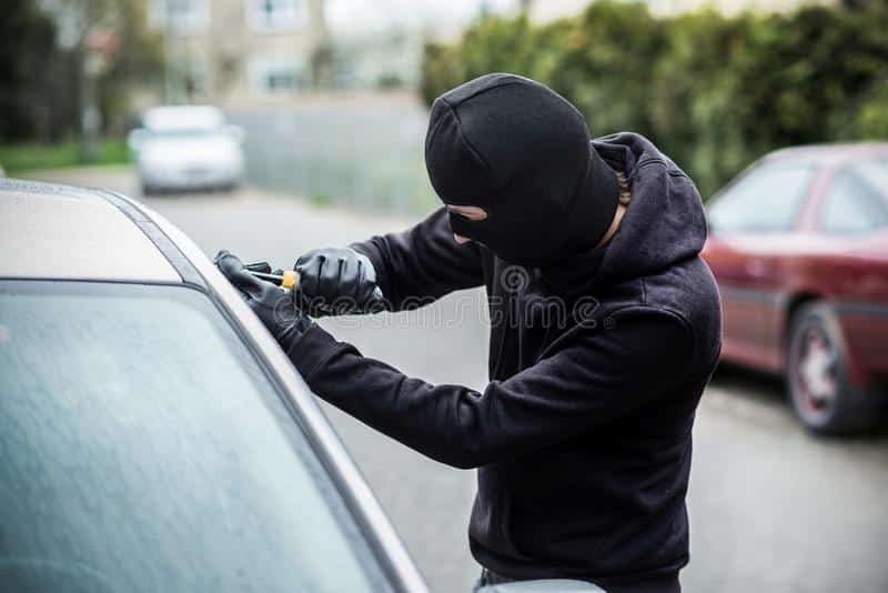 Car Thief Trying To Break Into A Car With A Screwdriver. Stock Photo ...